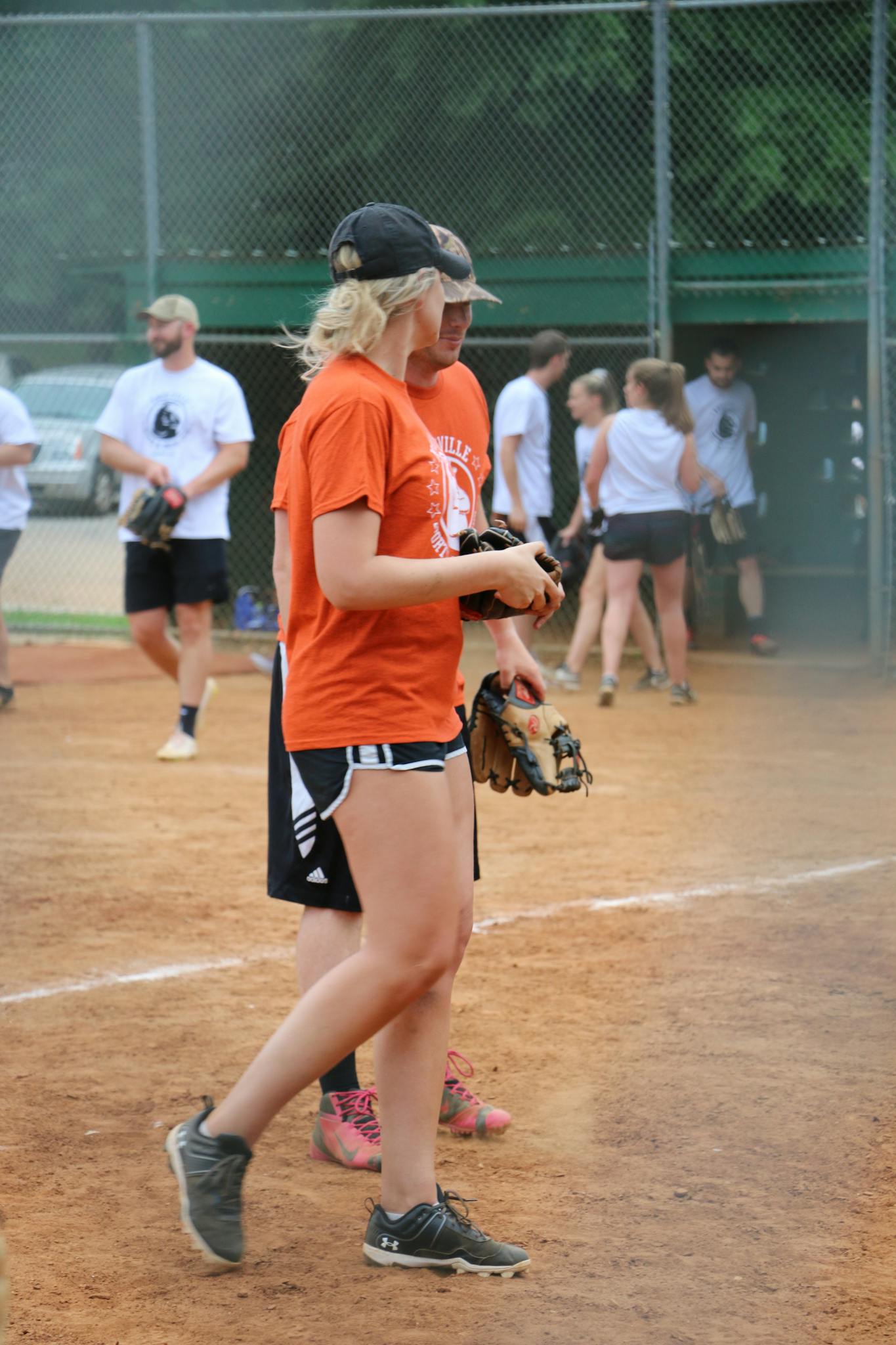 A youth softball team prepares for a game on a sunny day, showcasing teamwork and camaraderie.